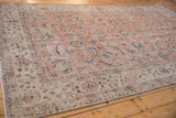 Distressed Sparta rug showing worn fringe, beige border, and faded pink field with navy Herati.