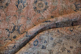 Distressed pile of the vintage Sparta rug, with faded dark pink and navy floral motifs.