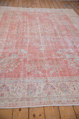 Distressed pink, ivory, blue thousand flower pattern with visible wear on a Sparta rug.