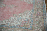 Distressed pink field and scrolling arabesque details of a vintage Turkish Sparta carpet corner.