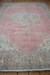 Distressed Sparta carpet, worn pink pile with traditional faded floral arabesques.