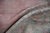 Distressed pink and ivory pile texture of a vintage Sparta rug with worn knot heads.