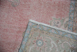 Worn pink pile texture, white fringe, and woven reverse showing pale blue, ivory.