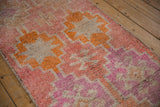 Vintage distressed Kurd rug pile, showing even wear, faded coral, blush, and geometric motifs.