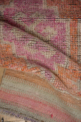 Distressed hand-knotted Kurd rug runner pile showing faded coral, blush, beige, and exposed foundation.