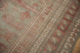 Distressed Oushak carpet detail, featuring pale raspberry geometric borders and serrated leaf pattern.