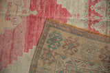 Distressed Oushak rug showing faded raspberry pile and woven reverse with aqua hook patterns.