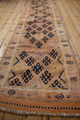 Vintage distressed Kurd runner end showing fringe, textured pile, and dark blue geometric patterns.