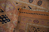 Visible woven foundation and textured pile of a distressed Kurd runner with geometric motifs.