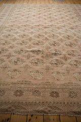 Distressed Turkmen carpet with muted dusty rose and brown geometric gul motifs.