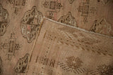 Distressed vintage Turkmen carpet with geometric gul motifs, showing pile and hand-knotted foundation.