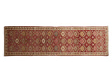 Distressed vintage Kurd rug runner, geometric floral design, dusty red, ivory, and gold.