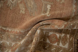 Soft pile and geometric border on a distressed Oushak rug in beige, ivory, and copper tones.