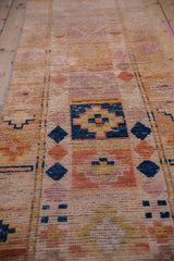 Vintage distressed Kurd rug detail: mostly even wear reveals navy, peach, apricot geometric motifs.