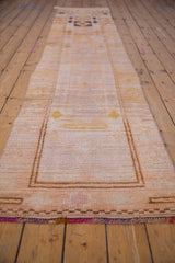 Distressed vintage Kurd runner's low pile, revealing peach and saffron yellow geometric pattern.