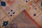 Distressed Kurd runner pile, exposed foundation, visible blue motifs, and reddish secured edge.