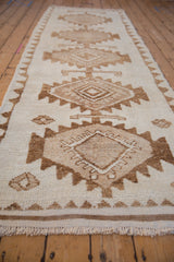 Kurd runner end with intact fringe and textural ivory, coffee brown geometric pattern.