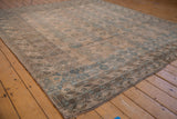 Intact selvage and muted dusty teal geometric patterns on the distressed Ersari rug.