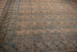 Distressed Ersari rug with dusty teal elephant's footprint guls and a geometric border.