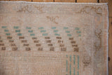 Distressed Sparta rug pile close-up; worn texture in ivory, dusty teal, and brown.