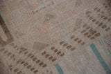 Distressed texture of the Sparta rug, showing coffee brown geometrics and dusty teal stripes.