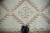 Vintage distressed geometric Kurd rug, short pile, braided fringe, checkered relief border.