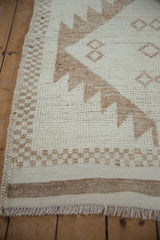 Thick braided selvage and checkered border of a distressed Kurd rug runner.