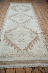 Distressed Kurd runner detail: checkered border, sharp serrated contours, and fringed end.