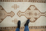 Distressed vintage Kurd runner: primitive geometric finials and ivory, brown pawn border detail.