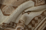 Distressed hand-knotted Kurd rug pile, showing primitive checkered designs in ivory and coffee brown.