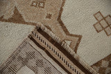 Kurd runner's folded corner shows intact side cord selvage, fringe, and primitive ivory, brown designs.