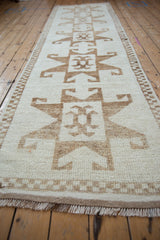 Angled view of a vintage Kurd runner's short pile and bold, primitive hook and latch design.