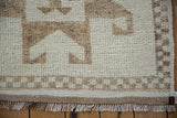 Short pile, checkered border, and secured fringed end of a vintage distressed Kurd rug runner.