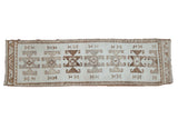 Vintage Kurd runner with geometric rams horn medallions in shades of brown over a distressed ivory field.