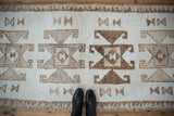 Geometric rams horn medallions and triangle border on a textured, distressed Kurd runner.