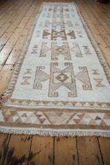 Vintage distressed Kurd runner seen from an angle, showing the repeating rams horn medallions.