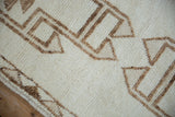 Distressed short pile texture with geometric primitive pattern in ivory and coffee brown shades.