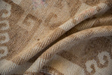 Hand-knotted pile and foundation texture of a distressed Kurd rug in sand and coffee brown.