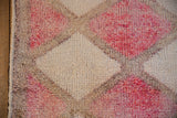 Distressed Kurd runner showing textured fuchsia, ivory, beige pile and intact corded selvage.