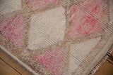 Distressed texture and varied fuchsia, ivory, and beige tones on vintage Kurd runner.
