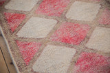 Distressed pile of the Vintage Kurd rug, showing fuchsia and ivory diamond panels and vinery.