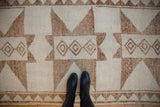 Low pile and visible knot heads on a distressed Kurd rug with a coffee brown starburst pattern.