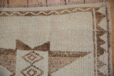 Close-up of a Kurd rug's textured wool pile, geometric border, and short ivory fringe.