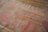 Textured pile detail of distressed Kurd runner, showing faded coral, pale fuchsia motifs.