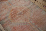 Faded coral and pale fuchsia geometric checkered motif on a distressed Kurd runner.