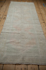 Close-up of distressed Oushak pile, showing wear to knot heads and faded ivory, blush, seafoam green.