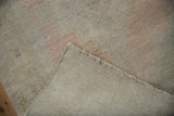 Texture of the distressed pile with muted colors, showing the plain woven foundation and fringe.