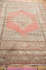 Dusty cherry red Kula rug with worn texture, beige geometric outlines, and visible foundation.