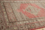Texture of Vintage Distressed Kula rug: muted cherry red field and worn beige border.