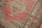 Distressed Kula rug detail: worn pile, showing foundation and soft cherry red with beige tones.